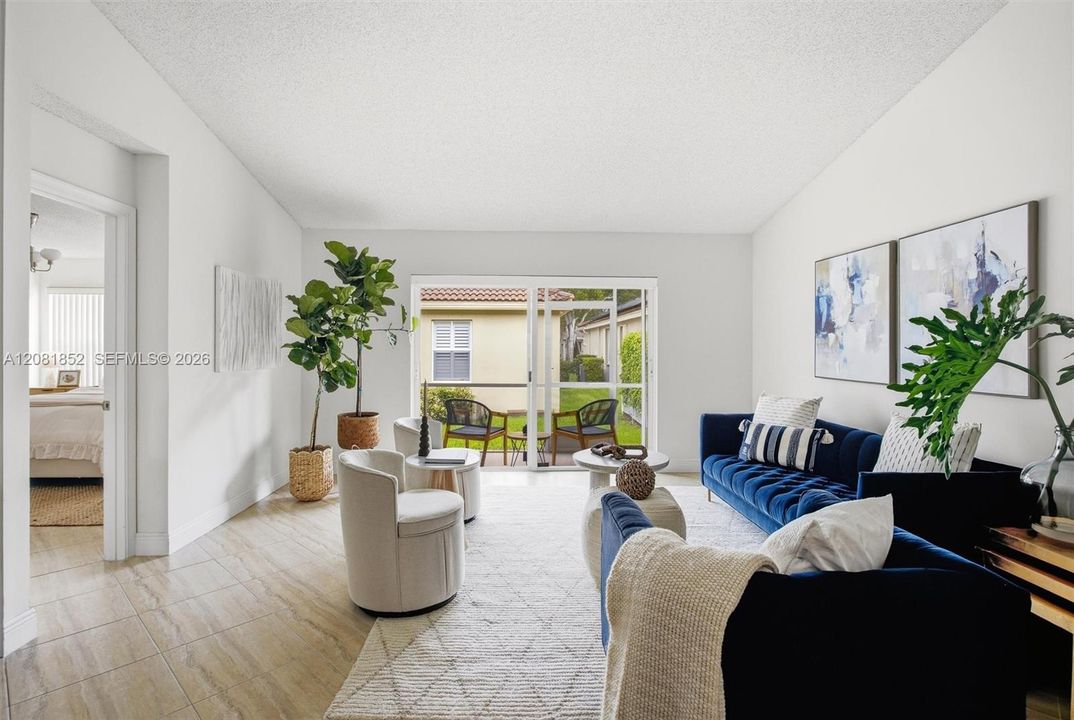 Sun-drenched living room with sliding glass doors leading to the covered lanai.