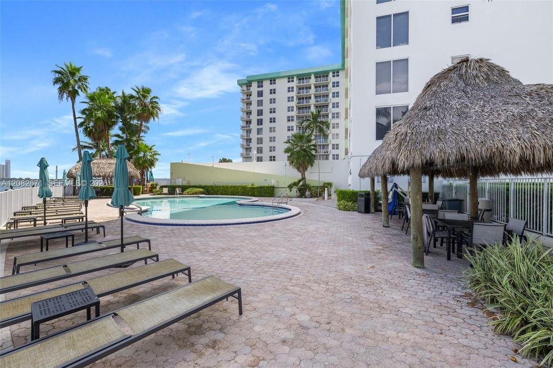 Heated bayfront pool with tiki hut and lounge deck.
