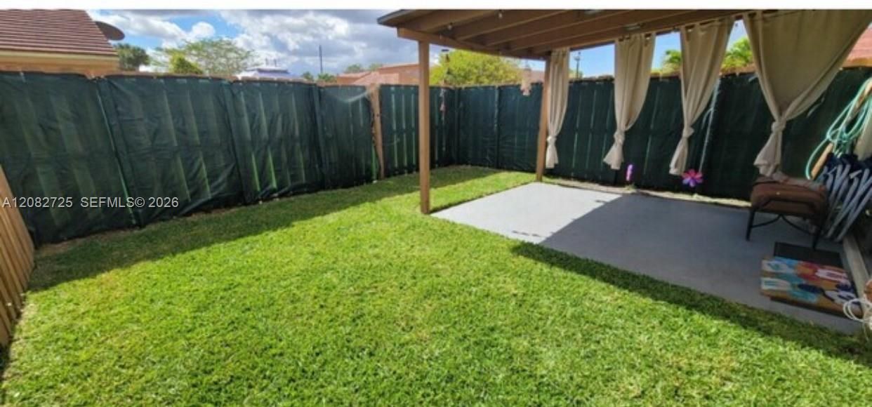 Photo showcasing the enclosed backyard and terrace area.