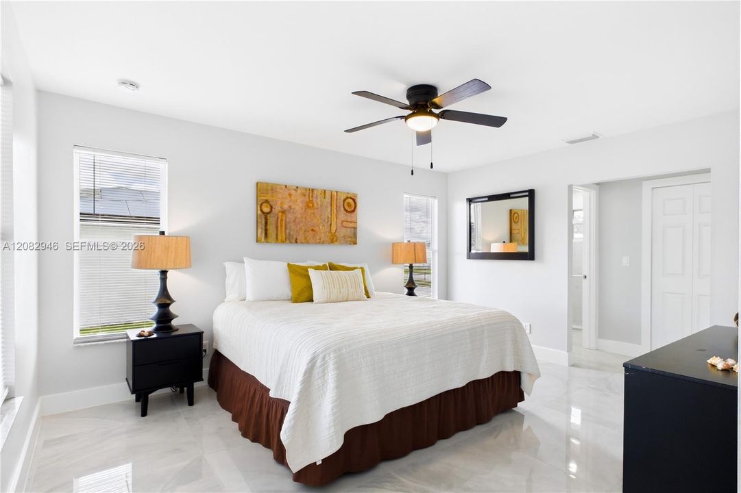 Spacious PRIMARY SUITE offers multiple windows, porcelain flooring, ceiling fan & WALK-IN CLOSET.