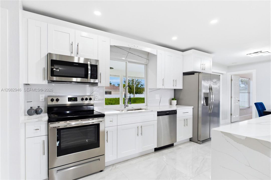 Modern pendant lighting, abundant cabinetry & open-concept design make this space equally beautiful & functional.