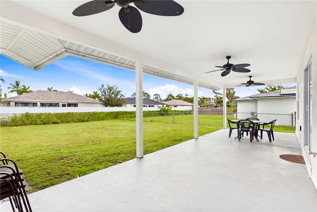 Outside to an EXPANSIVE COVERED LANAI w/ multiple ceiling fans, perfect for outdoor dining, grilling & relaxing.