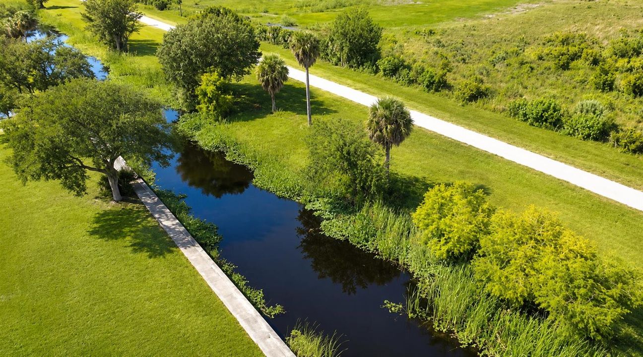 Sunlit Aerial Canal Through Green Parkla