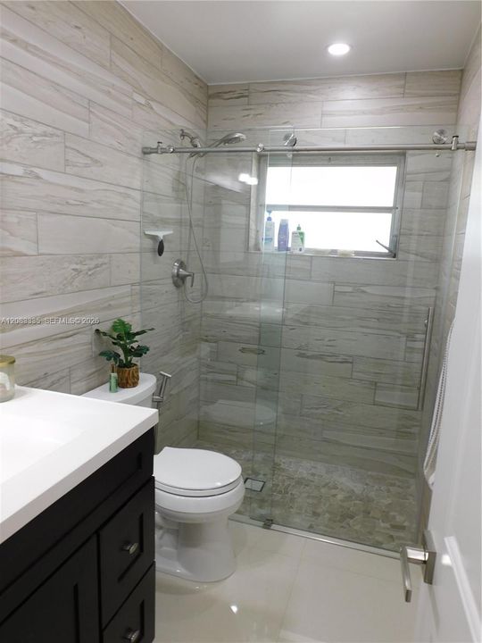 Primary Bathroom with Glass Shower Enclosure and very Stylish Tile Accents.
