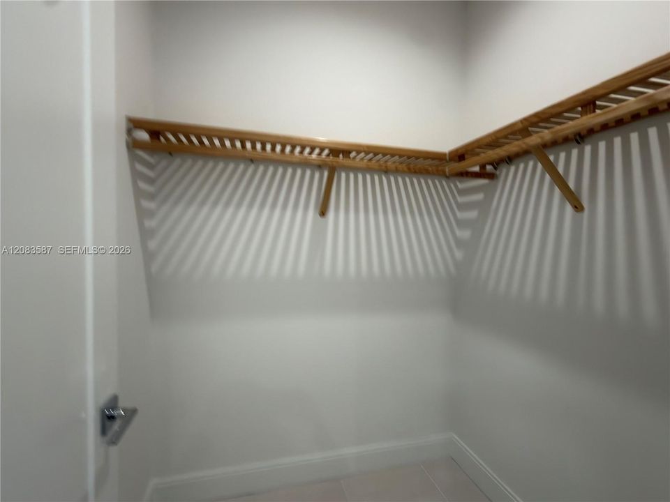 Storage area featuring built-in wooden shelving and neutral flooring