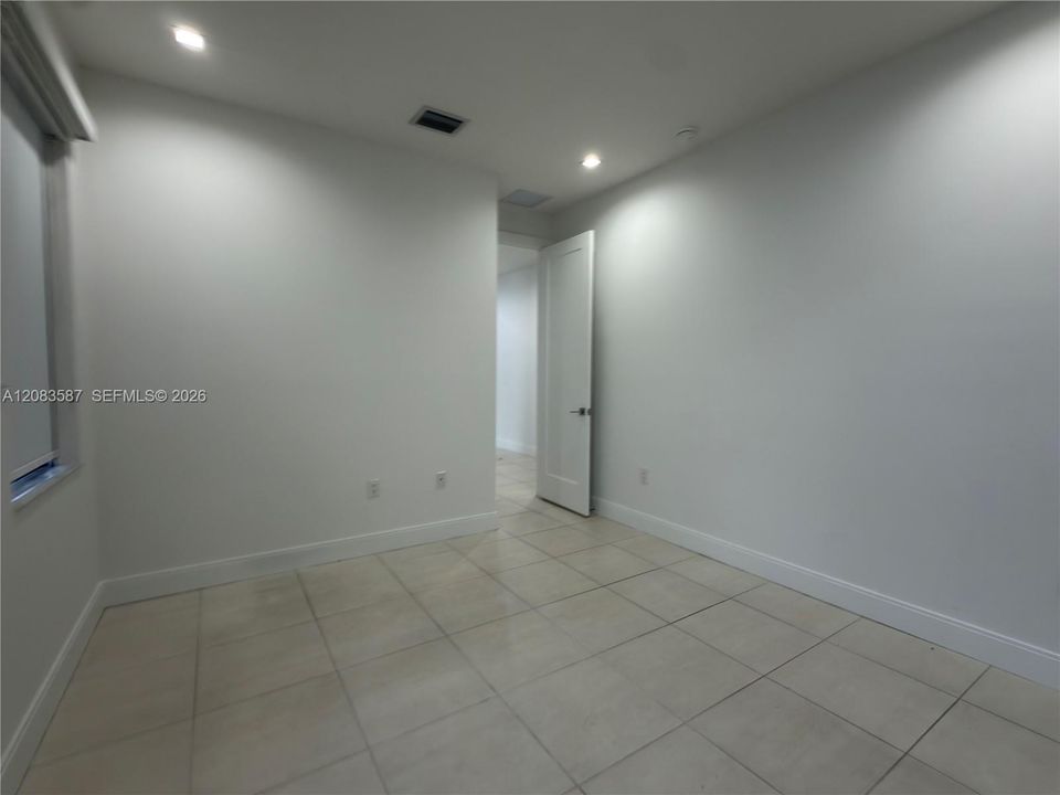 Interior room featuring neutral ceramic tile flooring, recessed lighting, and a solid-core interior door
