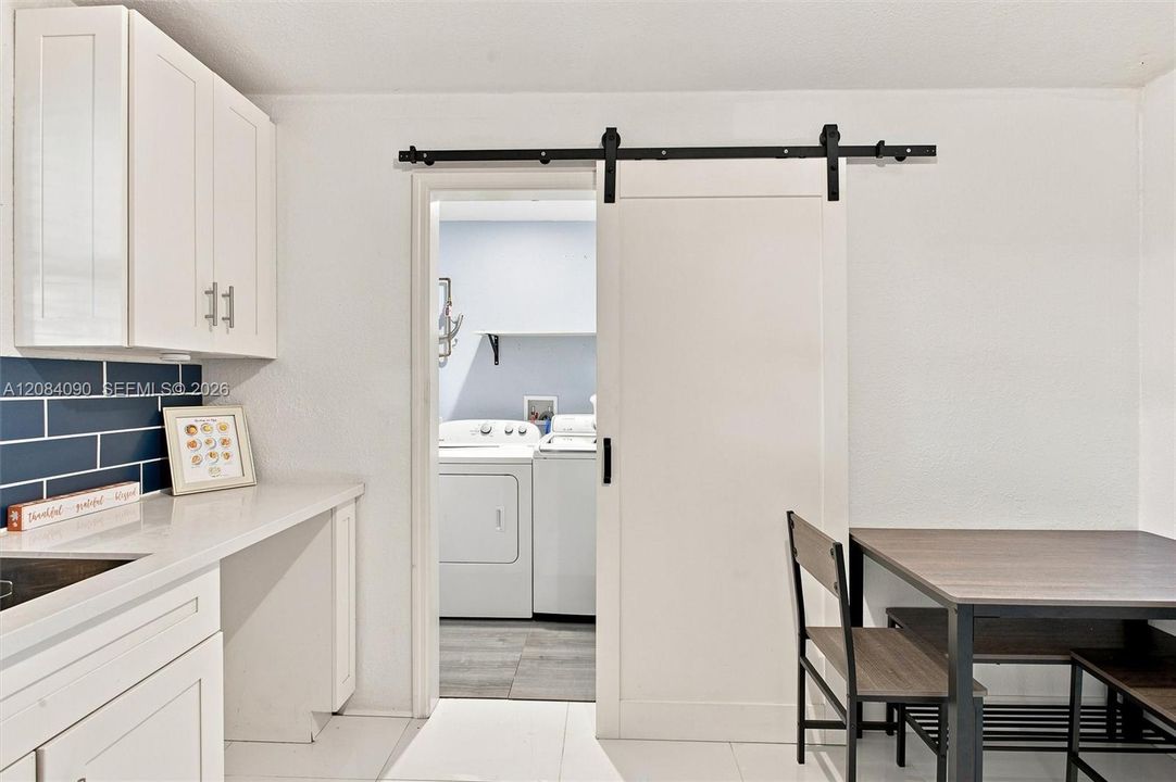 Large laundry room with plenty of storage next to kitchen