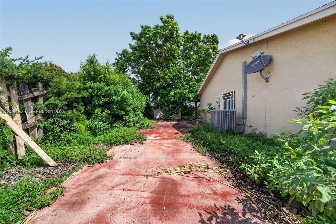 Side yard on the west side where the metal gate entrance is located.