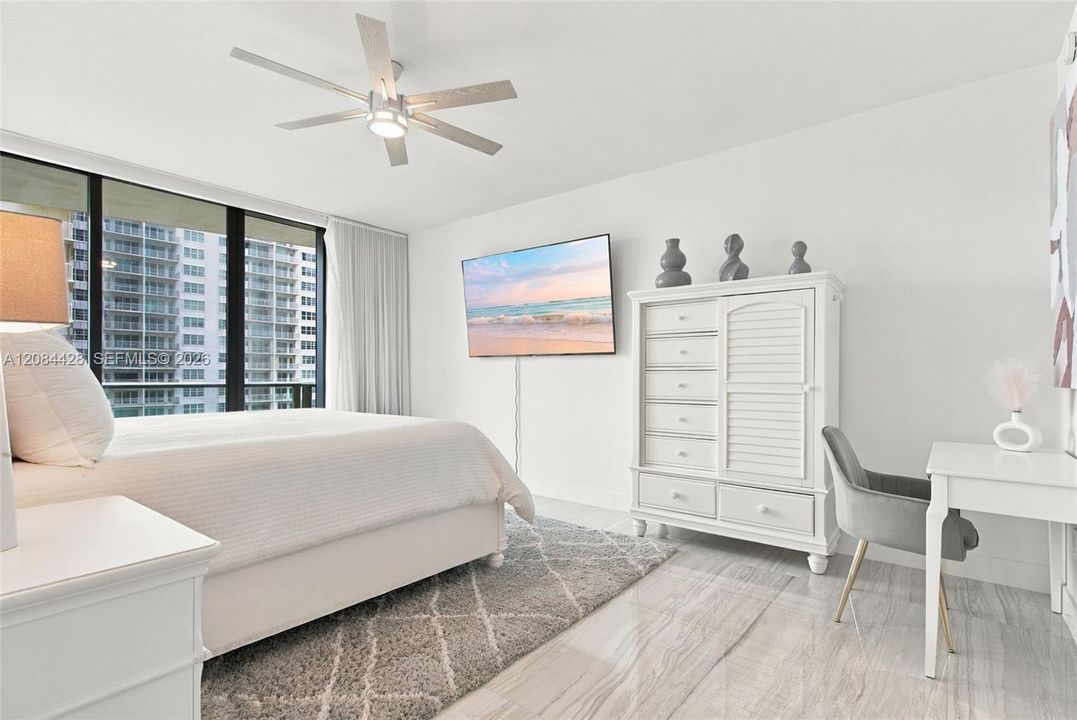 Spacious primary bedroom with an additional sitting or workspace area.