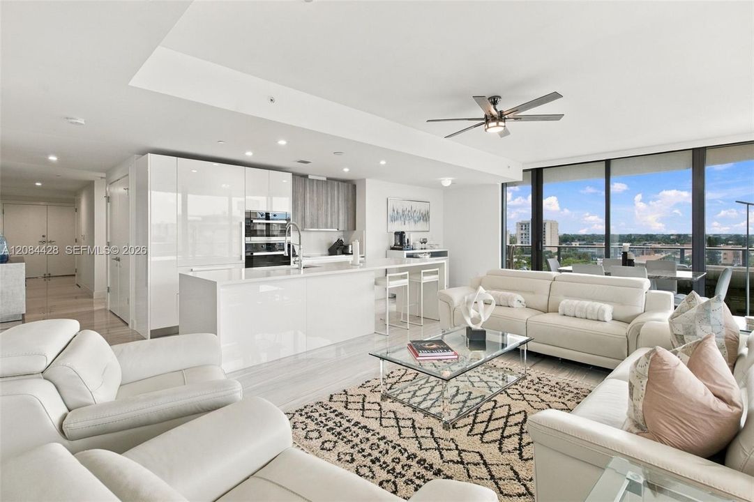 Spacious open-concept living room and kitchen with floor-to-ceiling glass.