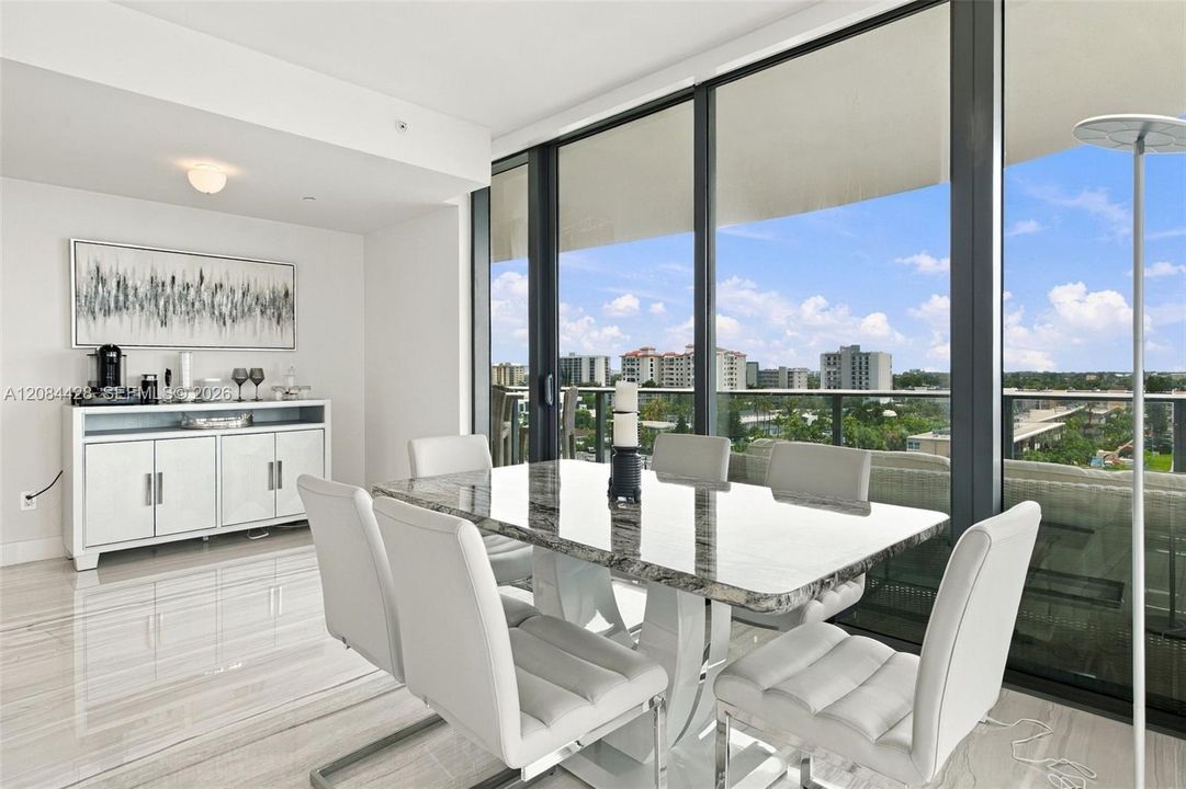 Dining area with floor-to-ceiling windows and direct balcony access.