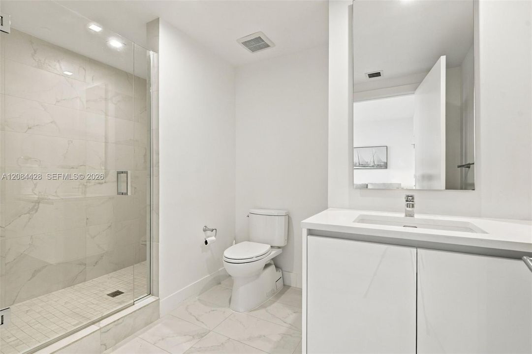 Guest bathroom with a glass-enclosed walk-in shower.