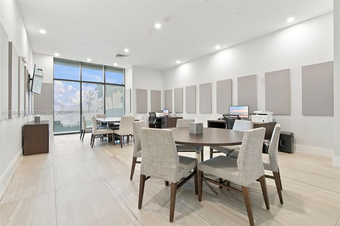 Modern business center and meeting room with ample seating for work, meetings, or collaboration.