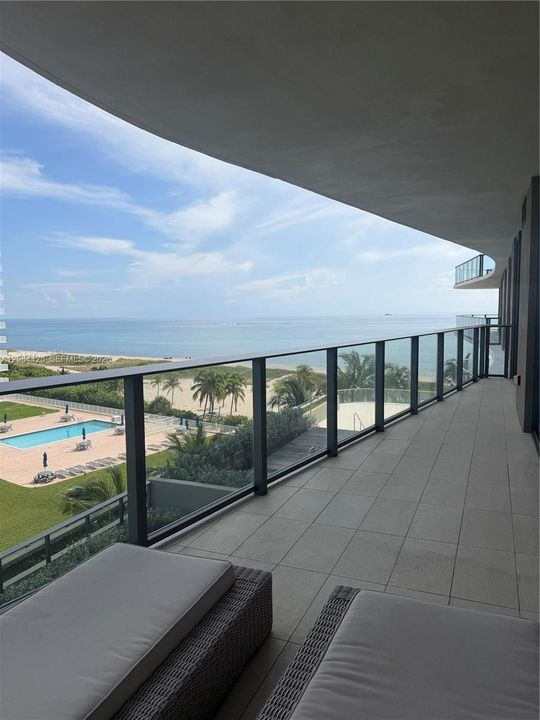 Furnished balcony offering comfortable outdoor living with ocean views.