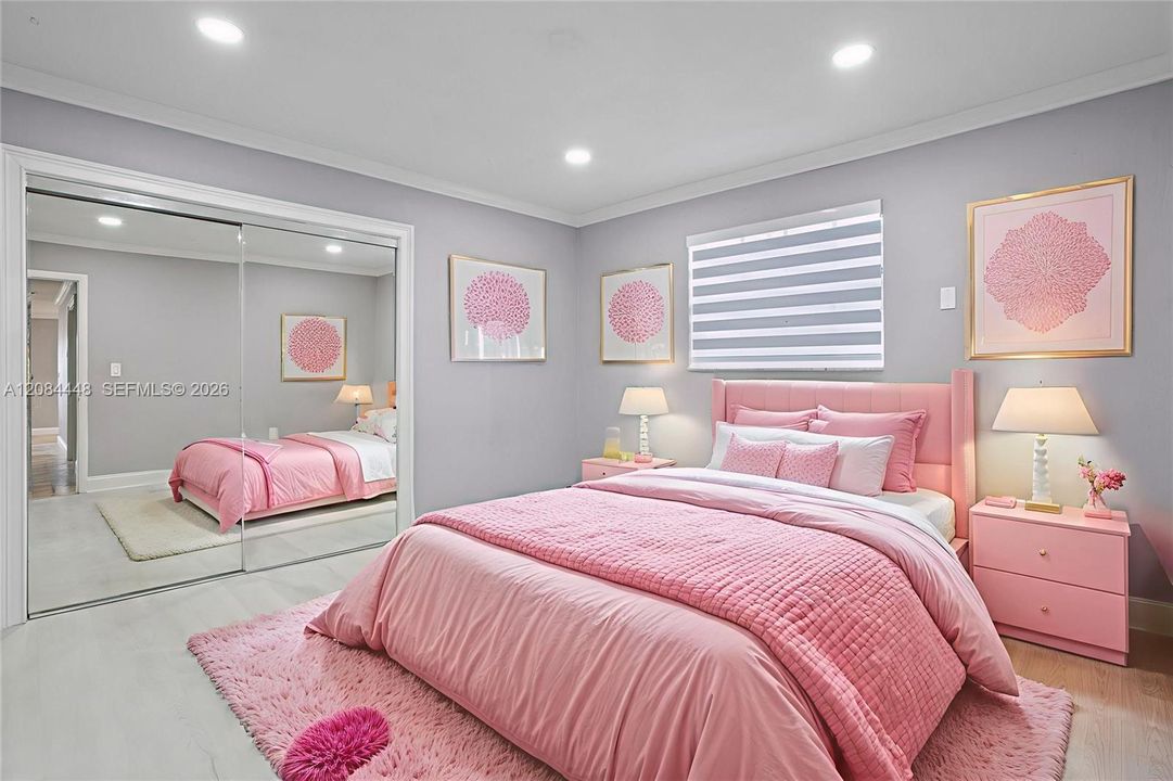 This delightful second bedroom offers a cozy and inviting atmosphere. Elegant crown molding and recessed LED lighting create a serene, modern feel. A large mirrored closet adds depth and functionality, while the window brings in plenty of natural light