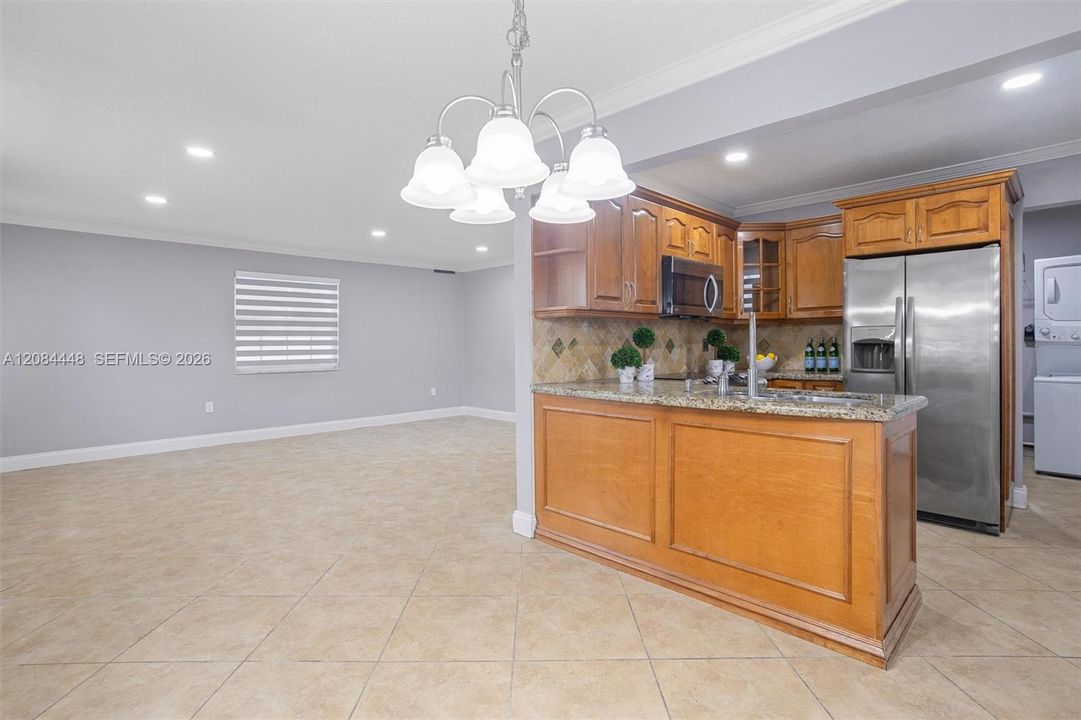 This beautifully appointed kitchen combines warmth and functionality with its rich wood cabinetry, granite countertops, and stainless-steel appliances
