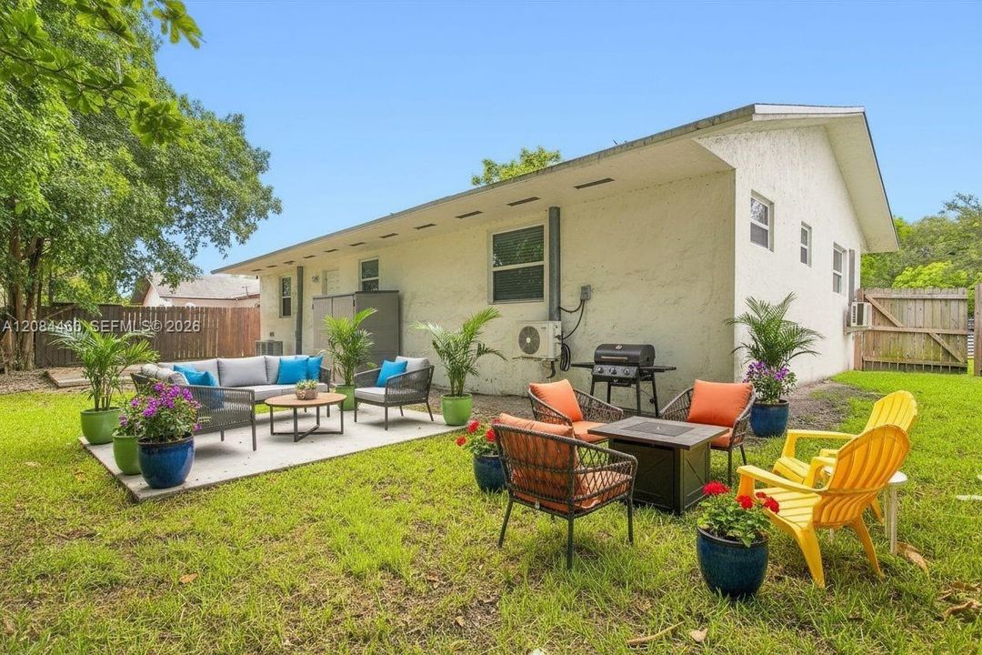 Spacious private backyard with a patio area perfect for relaxing or entertaining, surrounded by mature trees and a fenced yard for added privacy. *Photo virtually staged.*