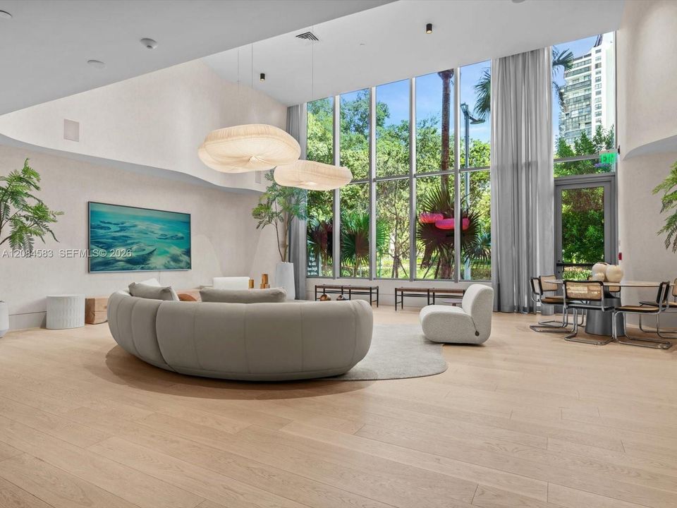 Resident lounge with floor-to-ceiling glass and lush views