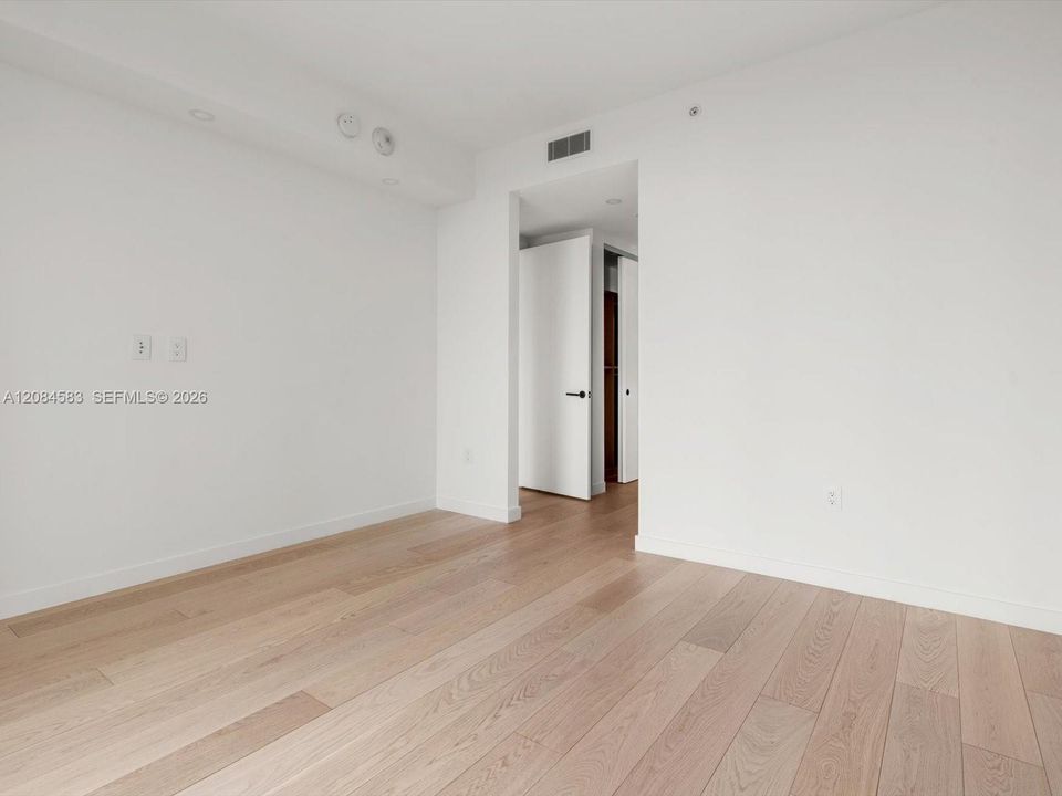 Primary bedroom with engineered wood flooring