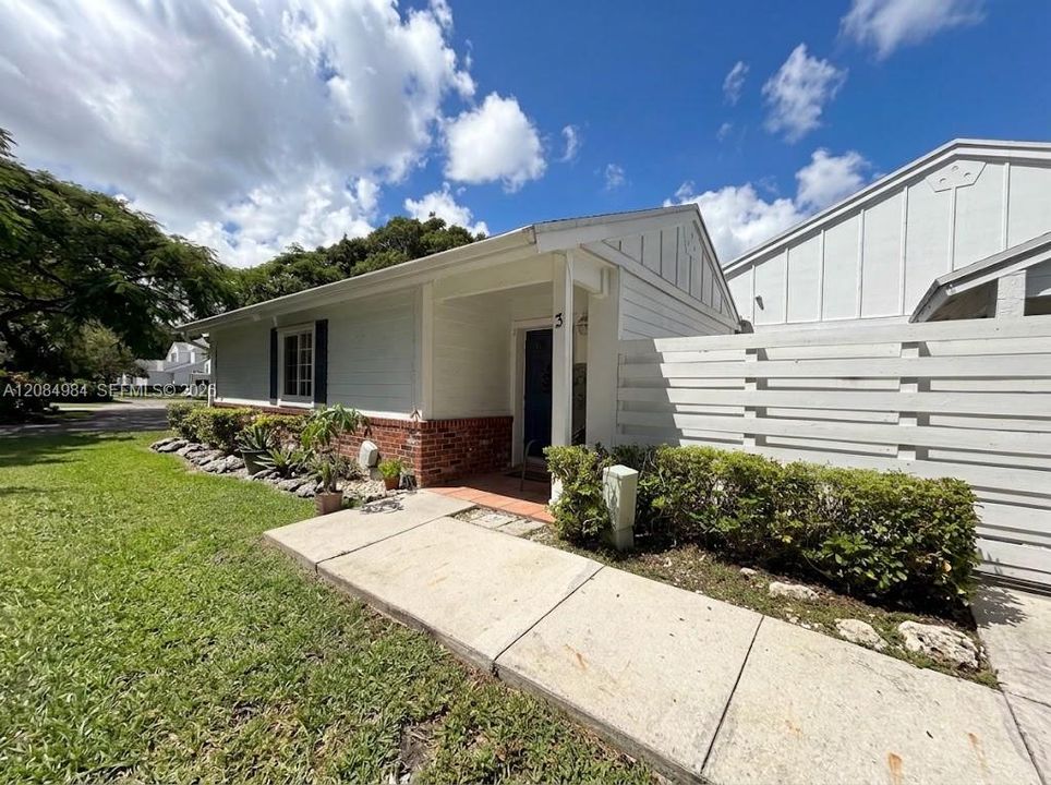 home exterior featuring a front entrance, well-maintained lawn, and paved driveway.