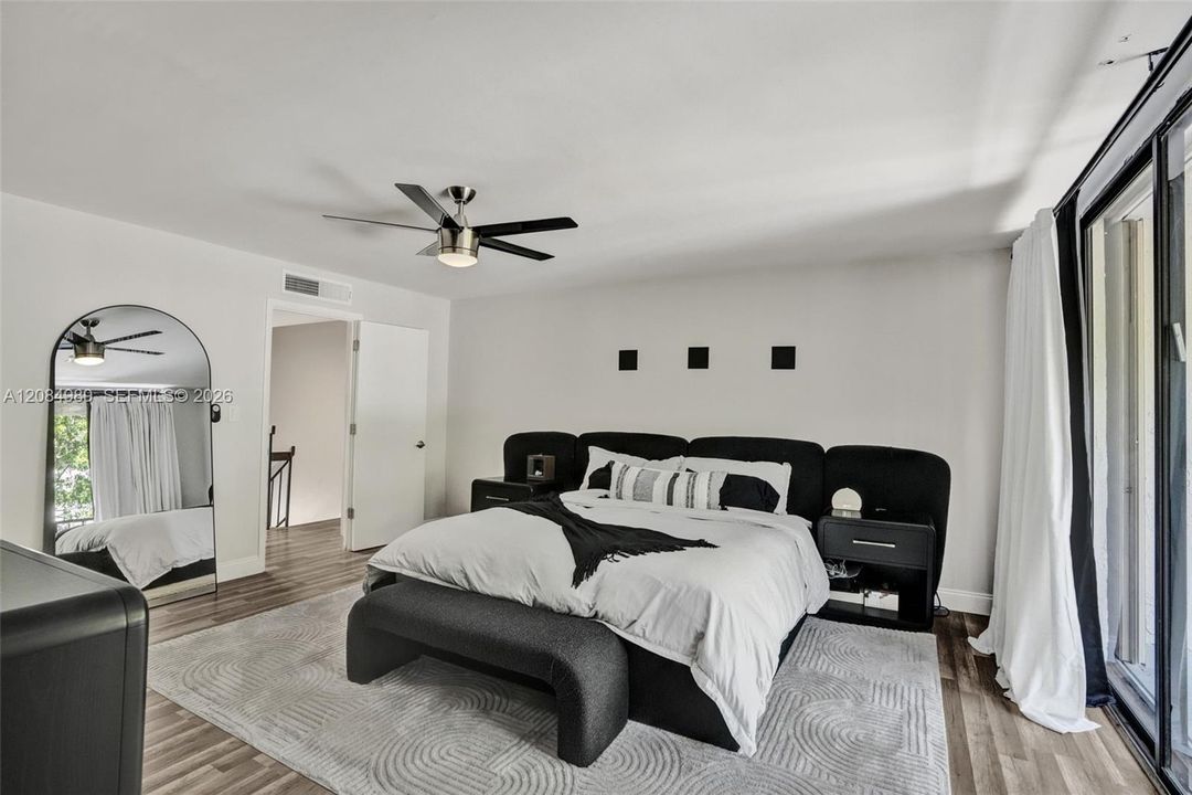 Interior space featuring wood-finish flooring, a contemporary ceiling fan, and sliding glass doors