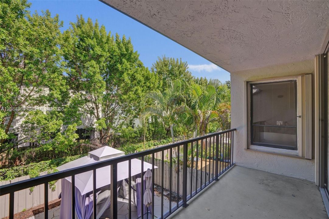 Covered balcony featuring concrete flooring and a metal railing