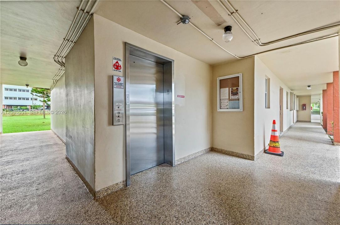 Building elevator with stainless steel doors and speckled aggregate flooring