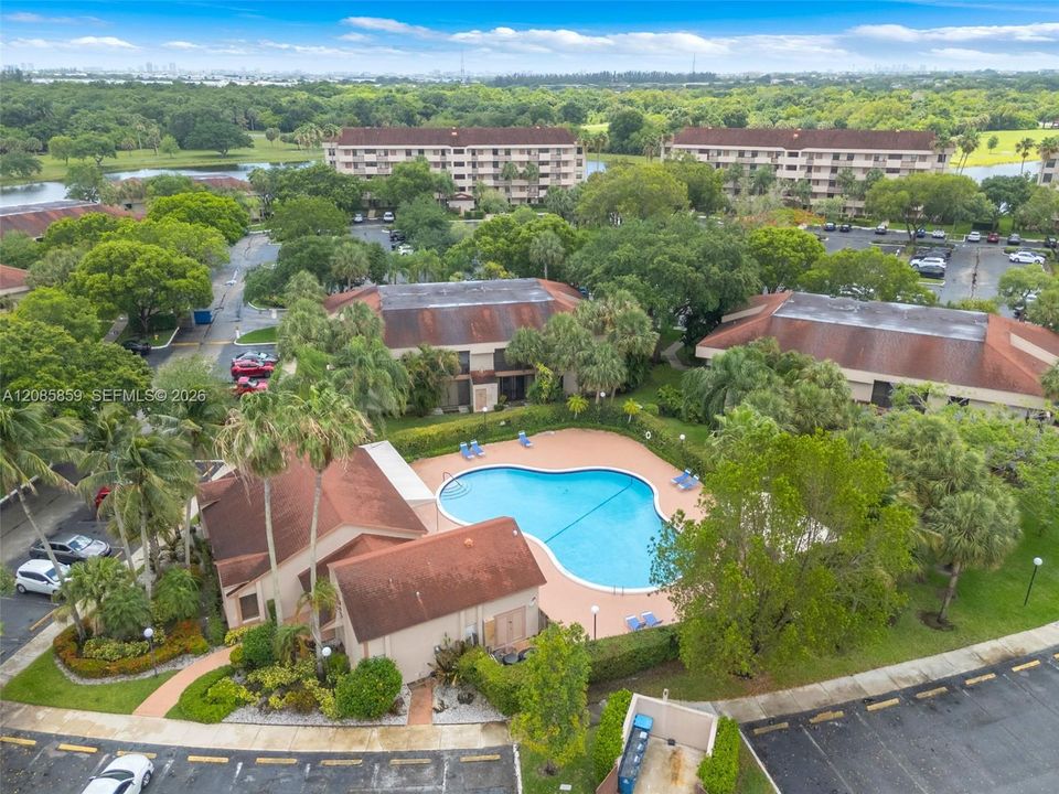 Beautiful aerial view of the community, pool area, surrounding greenery, and waterways.