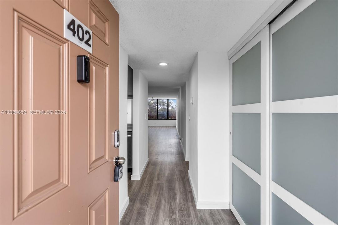 Welcoming unit entryway with smooth flooring and modern accent doors.