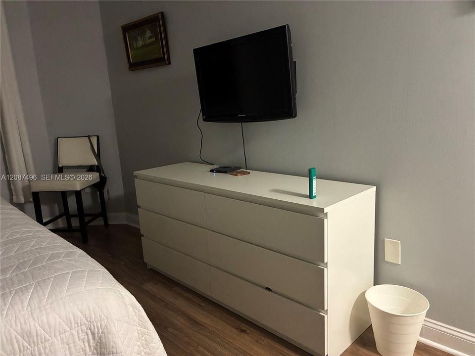 a TV on the wall with a sitting area nearby ..plenty of room to do this or that