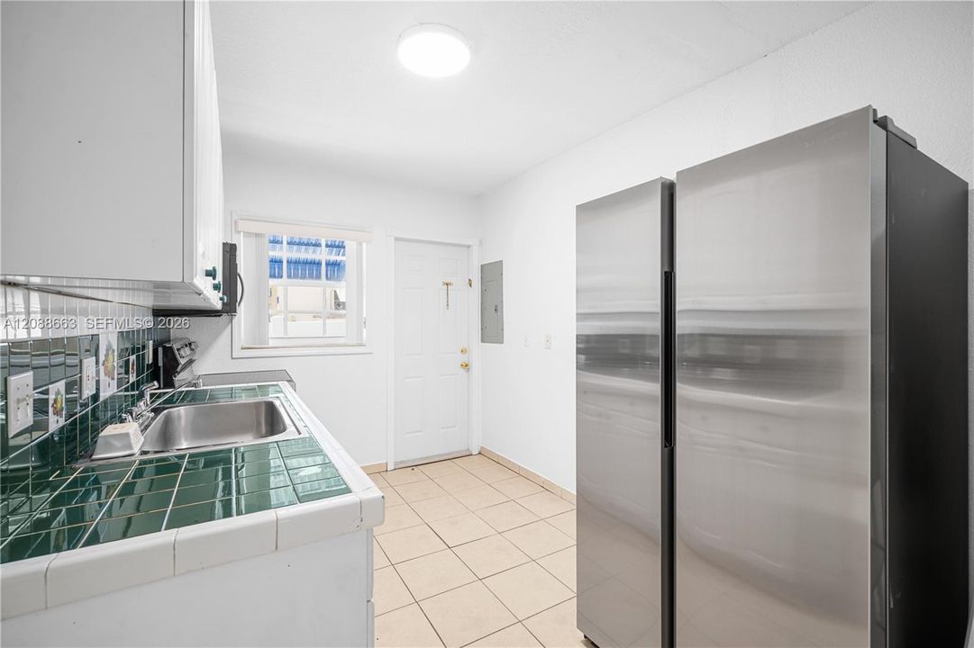 Kitchen features a large side-by-side stainless steel double-door refrigerator and generous cabinet storage space.