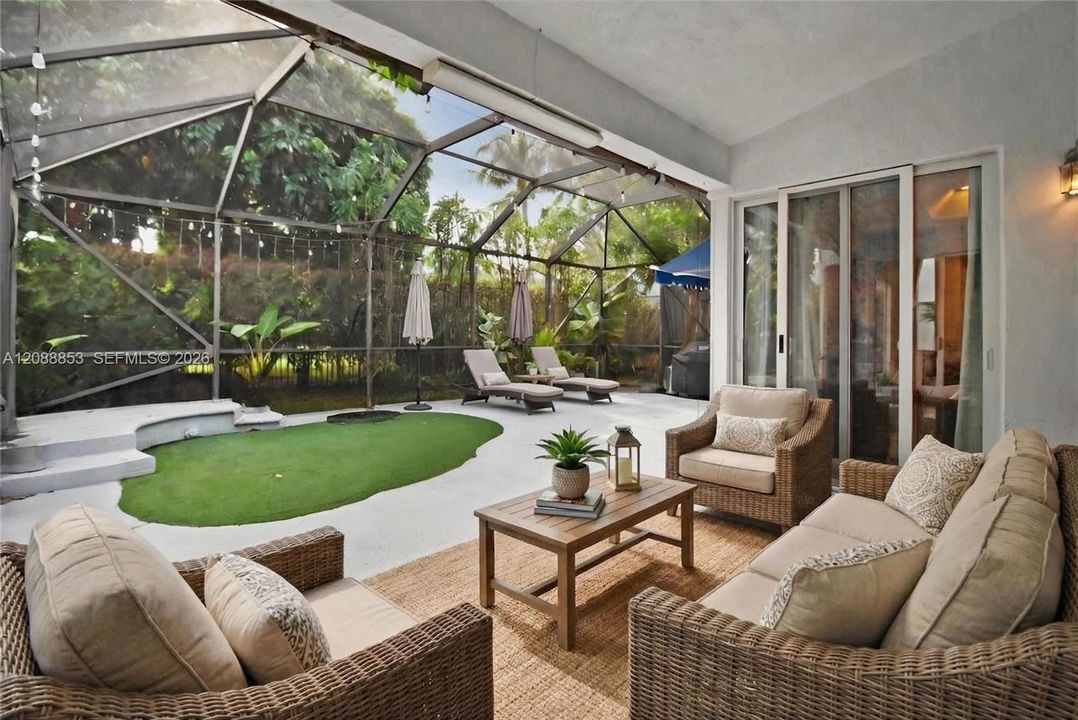 Virtual staging. Covered sitting area within screened patio enclosure