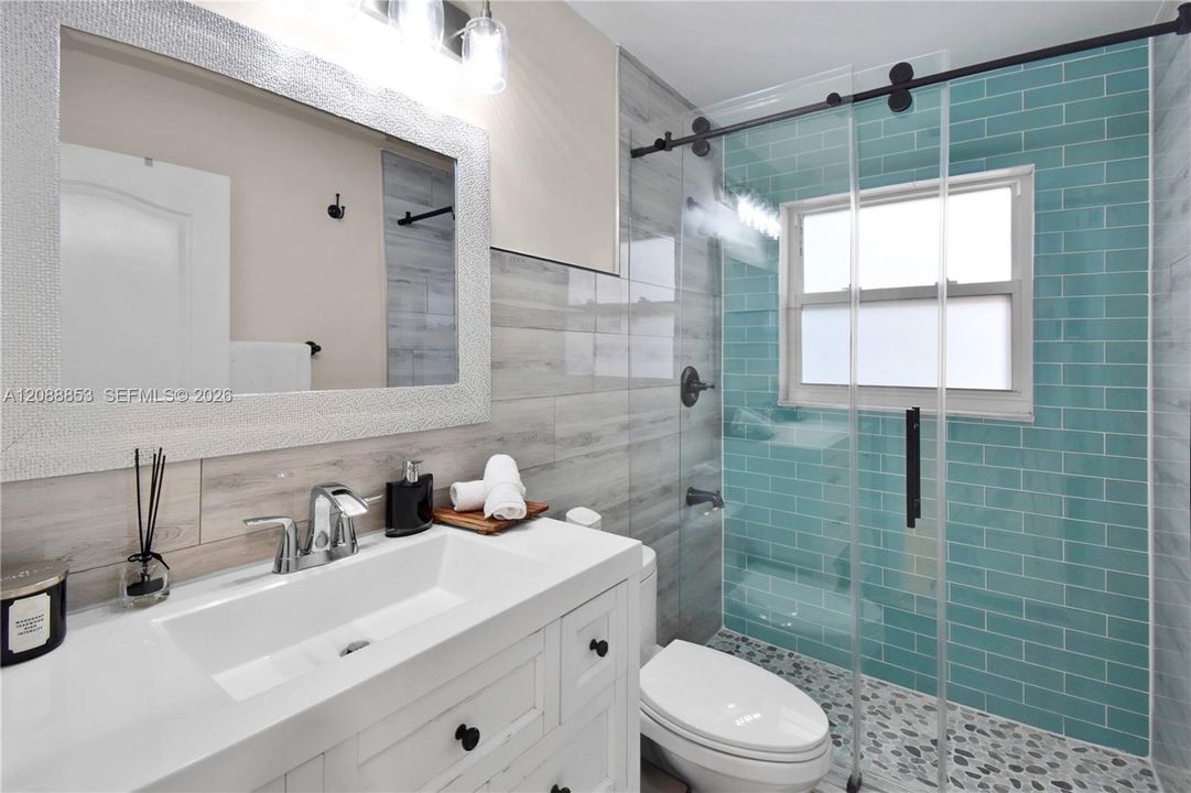 Updated bathroom with new vanity and fixtures,  and glass-enclosed shower