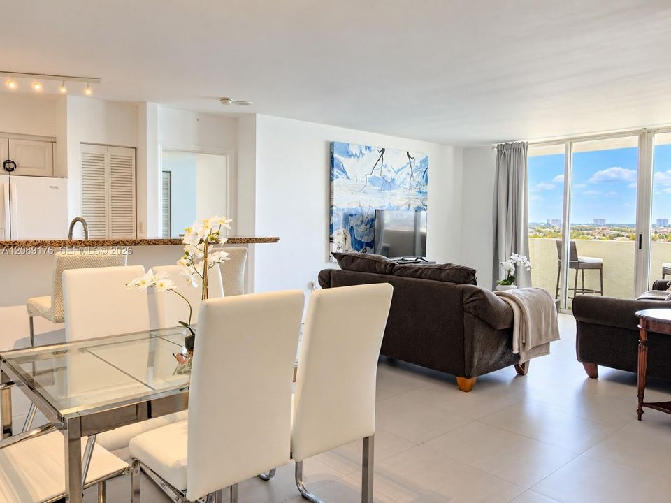 Open dining area seamlessly connected to the living room and balcony access