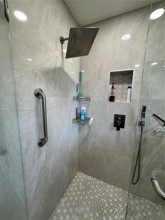 Beautiful large slab granite (or quartz) in walk-in shower. Top of the line fixtures.