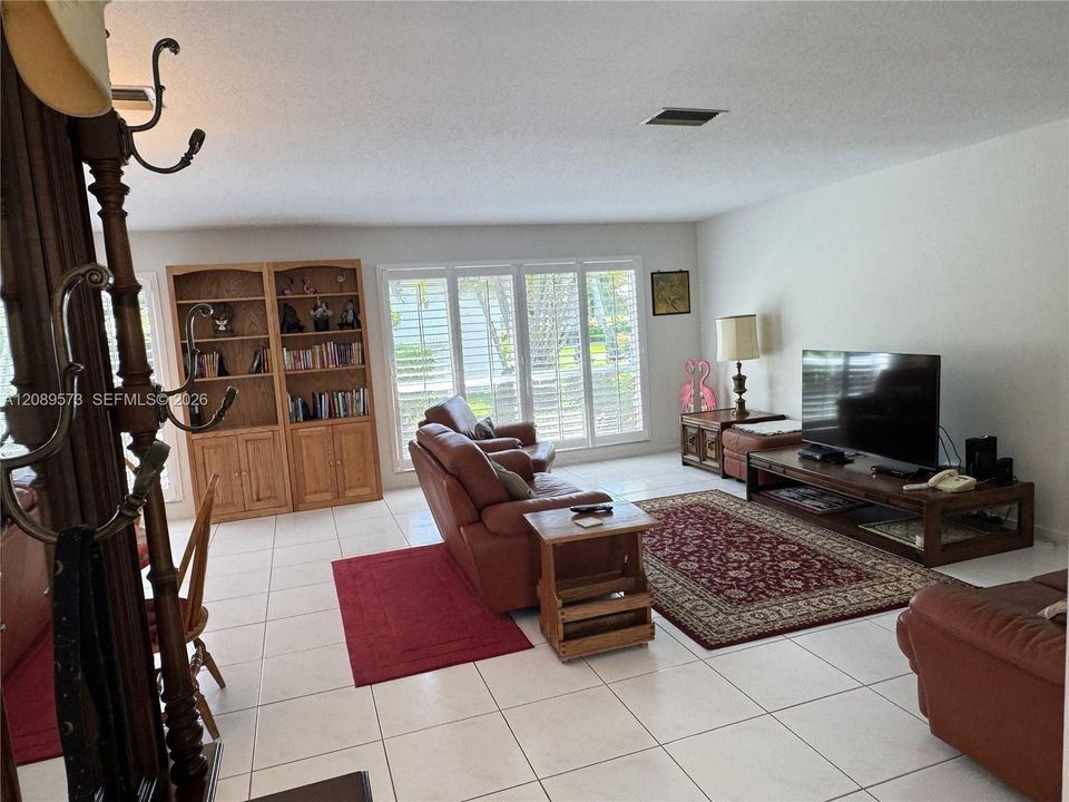 Large living room (view from foyer). Beautiful large windows to rear tastefully decorated with wide blade Plantation shutters to control light and temperature.