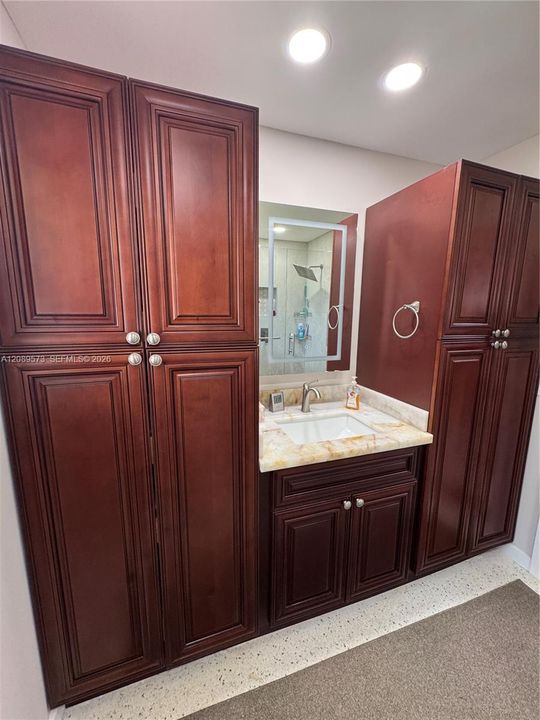 Beautiful custom cabinets in primary bathroom with marble sink vanity.