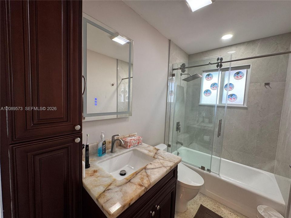 2nd Bathroom, custom shelving, marble top on vanity, beautiful tub/shower area with top of the line plumbing fixtures, plus Toto toilet.