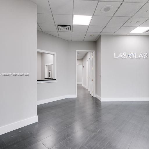 Waiting area to the right, reception window to the left, office suite through door