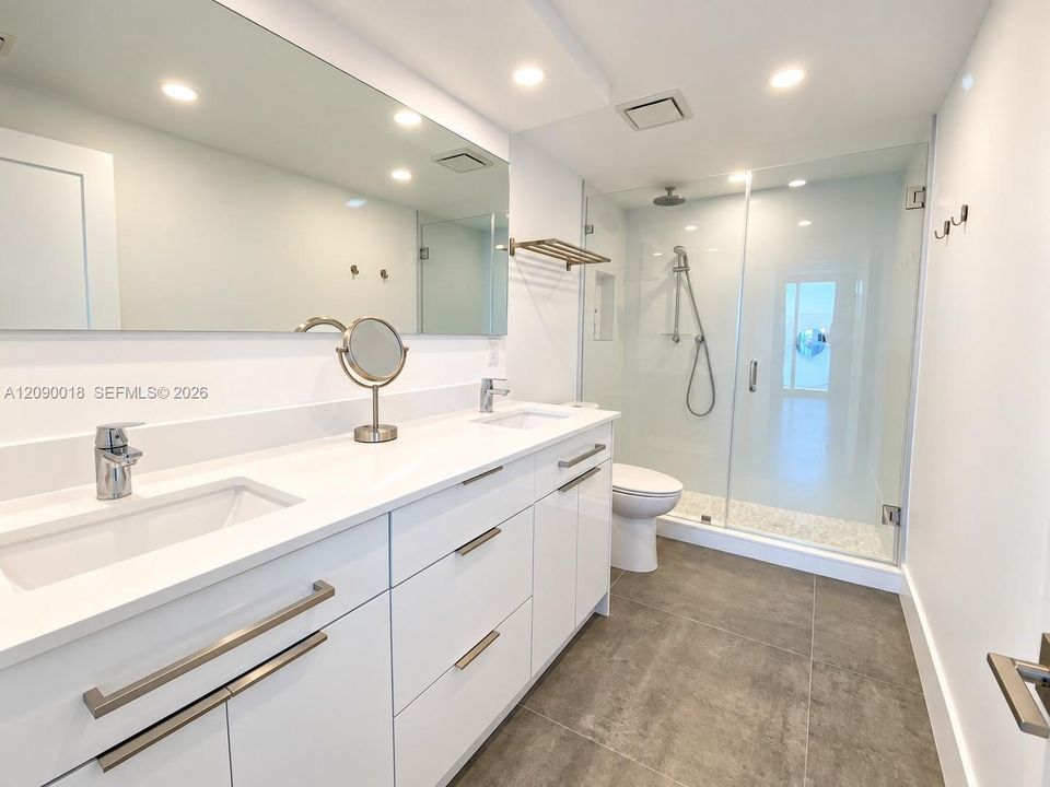 Primary bathroom with dual sink vanity and modern finishes.