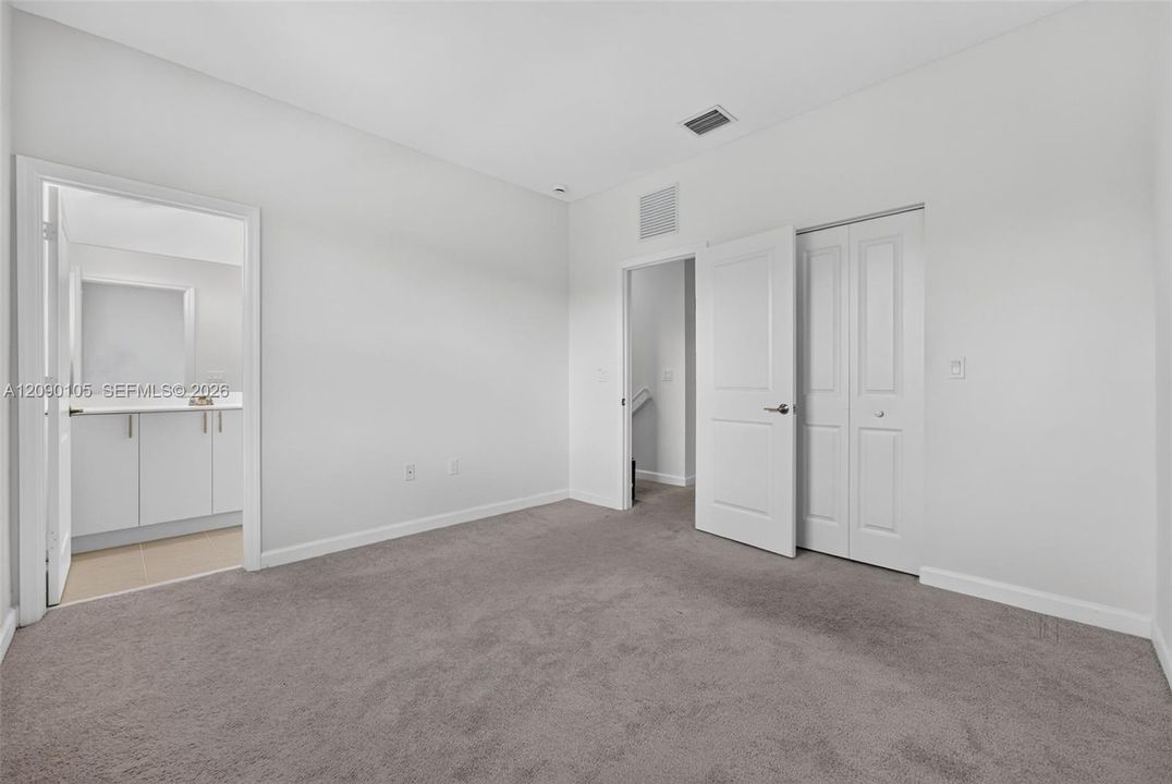 Neutral-toned wall-to-wall carpeting, solid-core interior doors, and built-in closet with double-panel doors