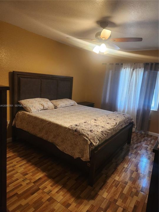 Multi-tone tile flooring and a ceiling-mounted light fixture with a three-blade fan