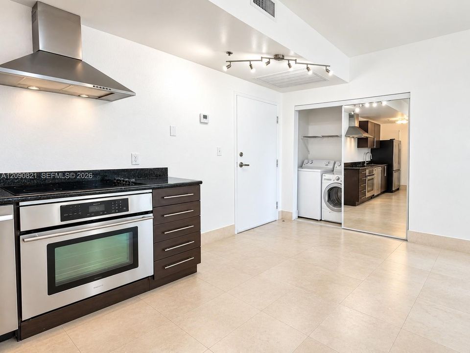 Open kitchen layout with breakfast bar counter and ample storage space.