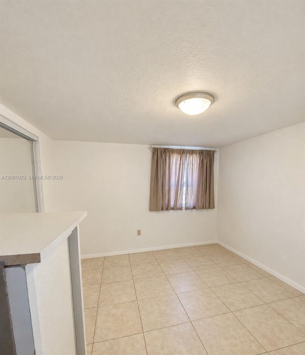 Interior space featuring tile flooring, neutral walls, and a ceiling-mounted flush light fixture