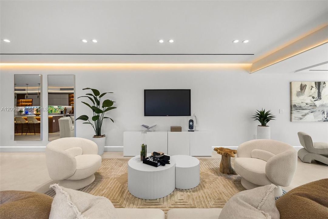 Modern interior featuring recessed lighting, cove ceiling accents, smooth wall finishes, and integrated custom cabinetry