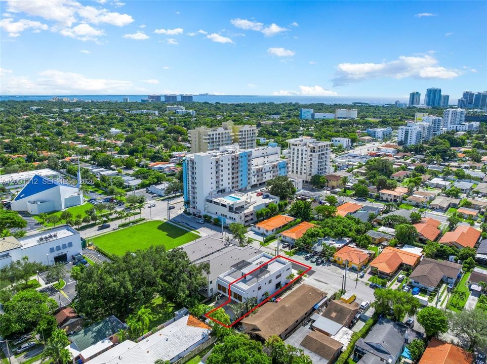 Aerial view of urban property featuring a flat-roofed building with a multi-level terrace