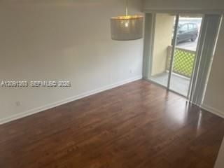 Wood-finish flooring, cylinder drum pendant lighting, and sliding glass door with lattice-patterned balcony railing