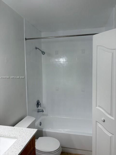 Full-height white tile shower surround, chrome shower fixtures, built-in tub, white vanity with stone-composite countertop, and a six-panel door