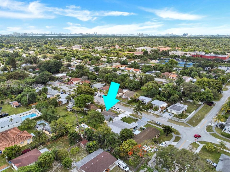 Aerial perspective featuring a residential lot with mature trees and hardscaped driveway
