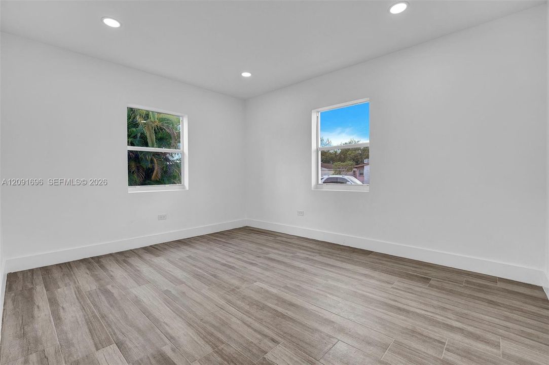 Neutral interior featuring wood-finish flooring, recessed lighting, and dual windows